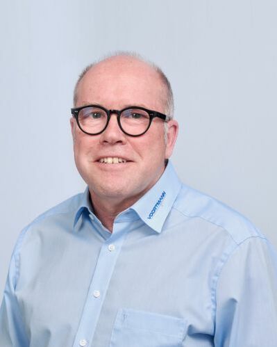 Porträt von Holger vor blauem Hintergrund