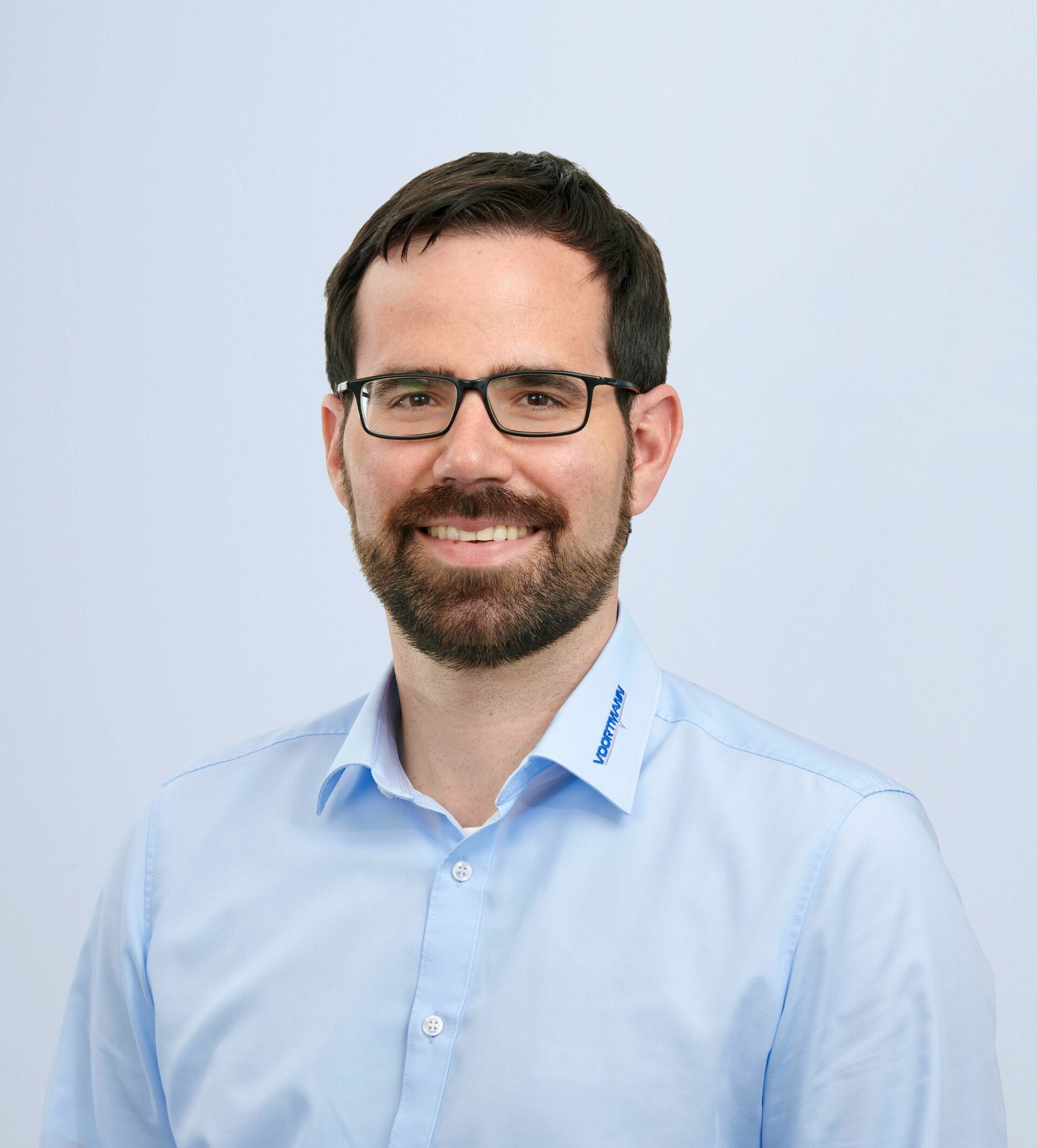Porträt von Christian Loy vor blauem Hintergrund